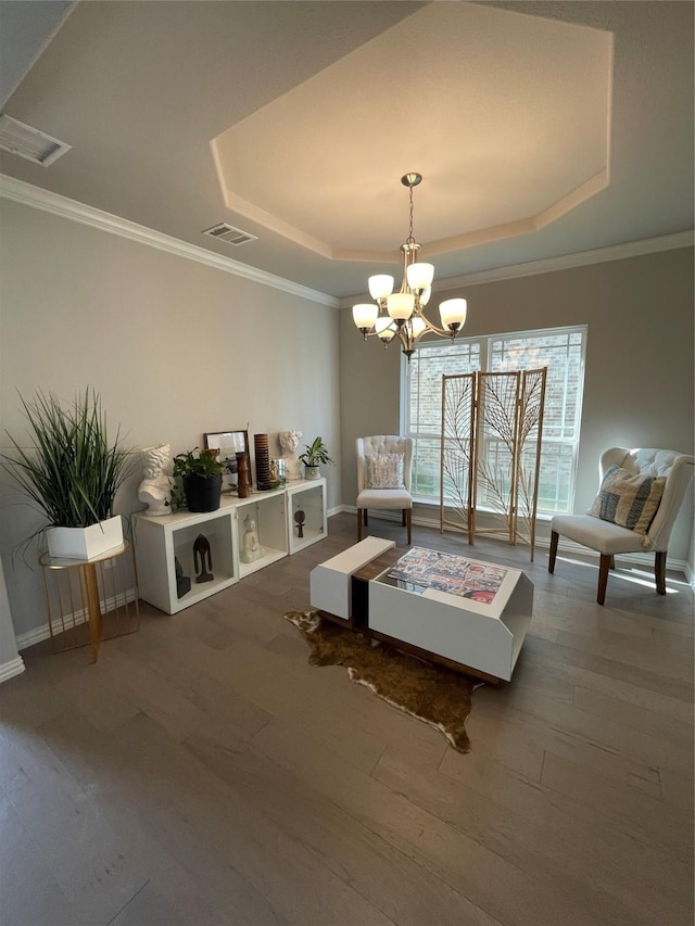 interior space with crown molding, hardwood / wood-style floors, a tray ceiling, and a chandelier