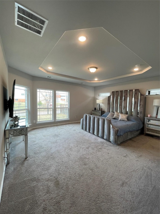 unfurnished bedroom featuring a tray ceiling and carpet floors