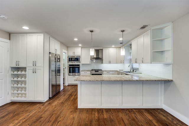 kitchen featuring white cabinets, wall chimney exhaust hood, kitchen peninsula, and appliances with stainless steel finishes