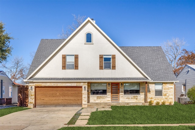 view of front facade with a front yard, a garage, cooling unit, and covered porch