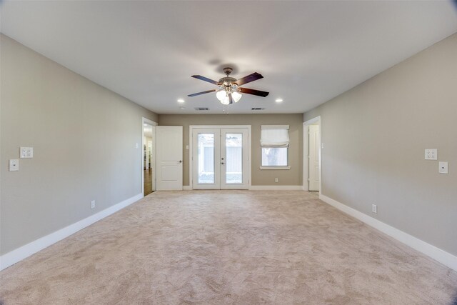 carpeted spare room featuring ceiling fan and french doors