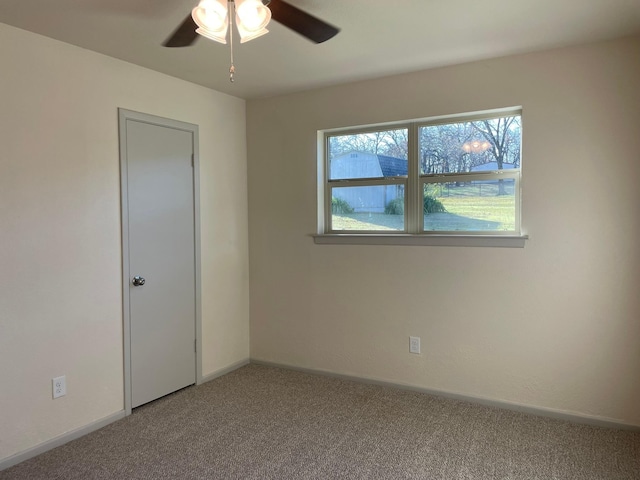 carpeted spare room with ceiling fan