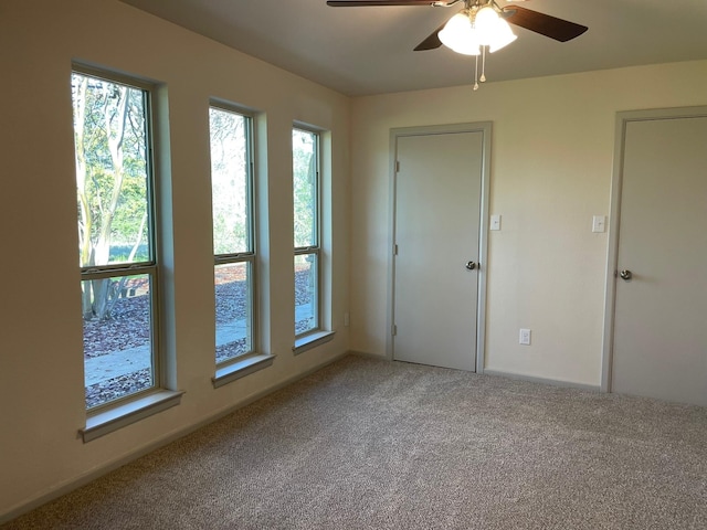 carpeted spare room with ceiling fan