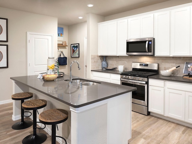 kitchen with sink, an island with sink, and appliances with stainless steel finishes