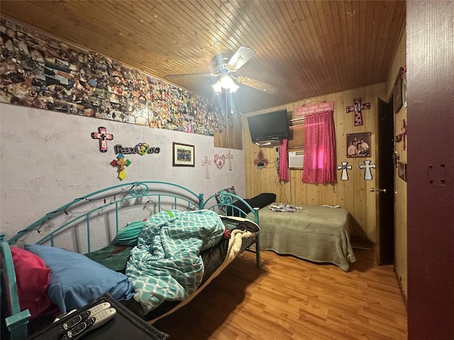 bedroom with wood ceiling, ceiling fan, wooden walls, and light hardwood / wood-style floors