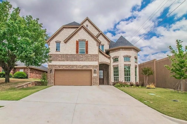 french country inspired facade featuring a front lawn and a garage