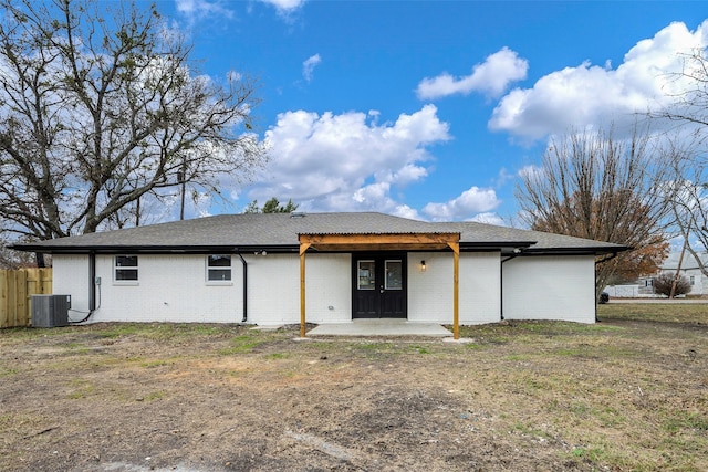 rear view of house featuring a yard, central AC, and a patio area