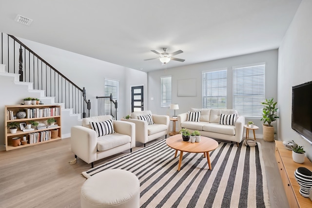 living room featuring light wood-type flooring and ceiling fan