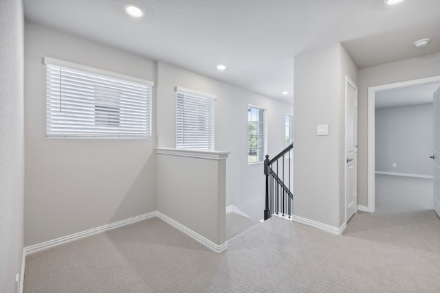 hallway with light colored carpet