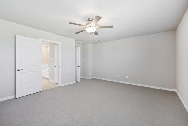 unfurnished bedroom featuring light colored carpet, ensuite bath, and ceiling fan