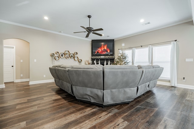 living room with ceiling fan, a fireplace, dark hardwood / wood-style flooring, and crown molding