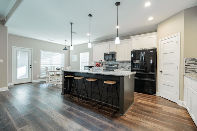 kitchen featuring white cabinetry, hanging light fixtures, stainless steel appliances, dark hardwood / wood-style floors, and an island with sink