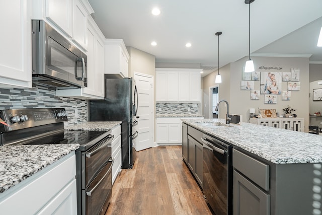 kitchen featuring stainless steel appliances, sink, a center island with sink, hardwood / wood-style floors, and white cabinetry