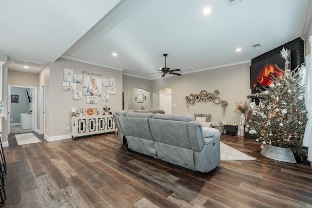 living room with dark hardwood / wood-style floors, ceiling fan, and ornamental molding