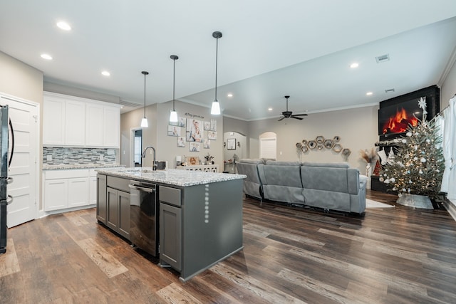 kitchen with ceiling fan, a center island with sink, dark hardwood / wood-style floors, white cabinetry, and hanging light fixtures