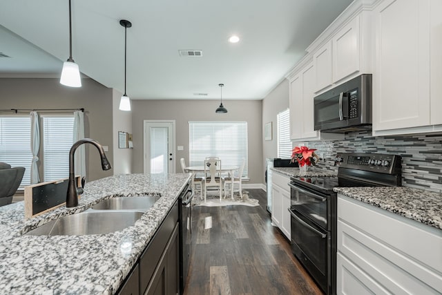 kitchen with appliances with stainless steel finishes, dark hardwood / wood-style flooring, sink, decorative light fixtures, and white cabinetry