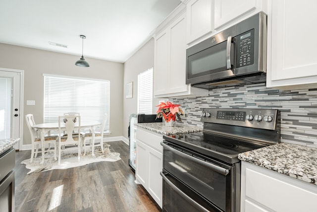 kitchen with white cabinetry, stainless steel appliances, dark hardwood / wood-style floors, backsplash, and pendant lighting