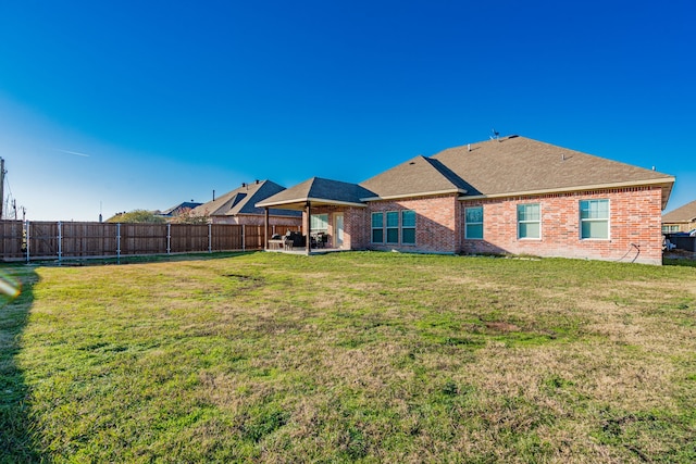 back of house with a patio area and a yard