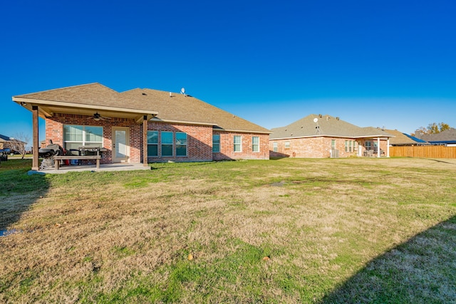 rear view of house featuring a lawn, ceiling fan, and a patio