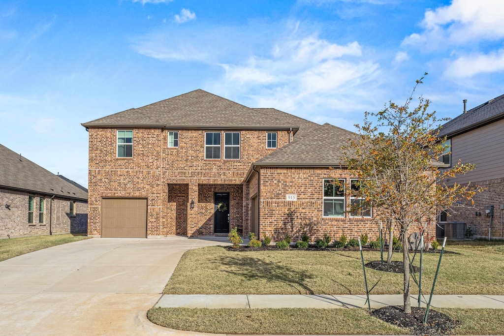 view of front of property featuring cooling unit, a garage, and a front yard