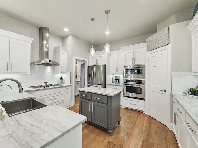 kitchen featuring wall chimney exhaust hood, stainless steel appliances, sink, gray cabinets, and white cabinetry