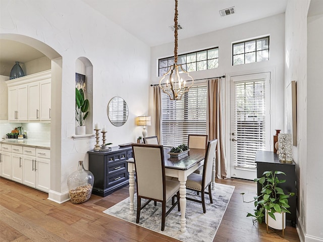 dining area with dark hardwood / wood-style floors and an inviting chandelier