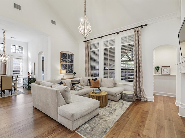 living room with a high ceiling, hardwood / wood-style flooring, and a notable chandelier