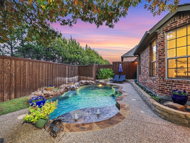 pool at dusk with a patio area