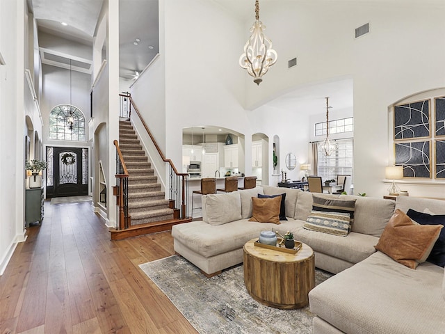 living room featuring a high ceiling, plenty of natural light, and a notable chandelier