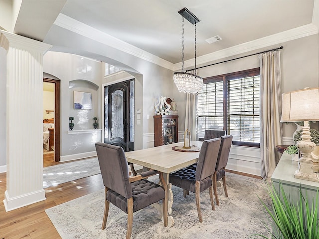 dining area featuring ornamental molding, a chandelier, and light wood-type flooring