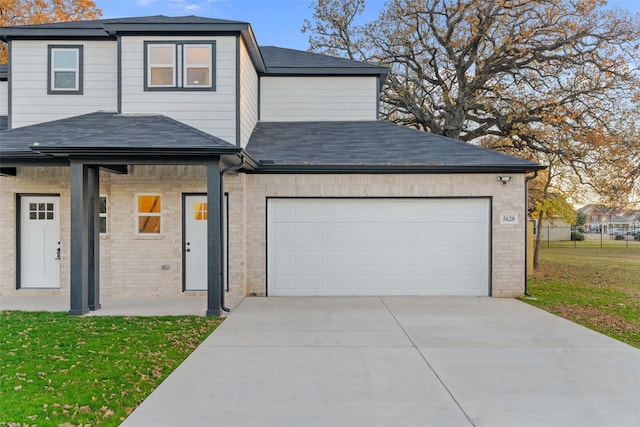 front facade with a garage and a front lawn