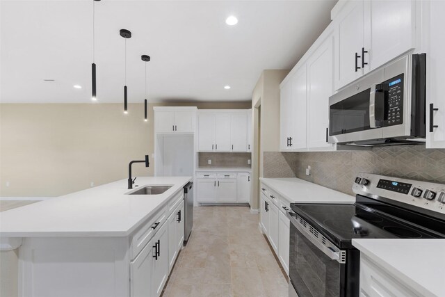 kitchen with sink, an island with sink, appliances with stainless steel finishes, decorative light fixtures, and white cabinetry