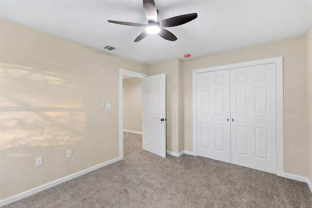 unfurnished bedroom with carpet, ceiling fan, and a closet