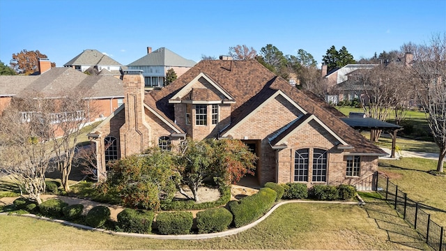 view of front of property featuring a front yard, brick siding, and fence