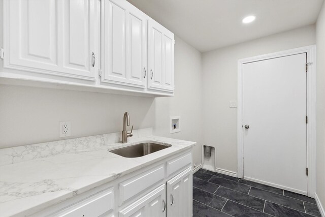 laundry area featuring cabinets, hookup for a washing machine, hookup for an electric dryer, sink, and dark tile patterned flooring