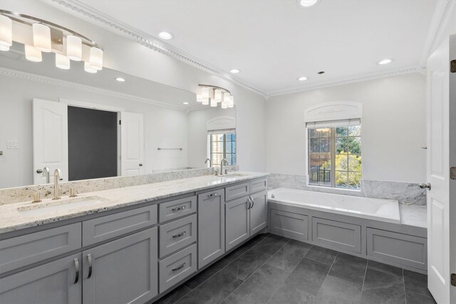 bathroom featuring tile patterned floors, vanity, ornamental molding, and a tub