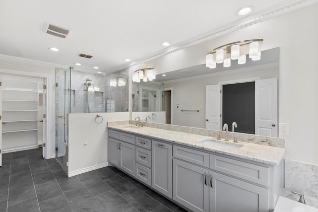 bathroom with a sink, visible vents, a shower stall, double vanity, and crown molding