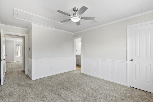 spare room featuring ceiling fan, light colored carpet, and ornamental molding