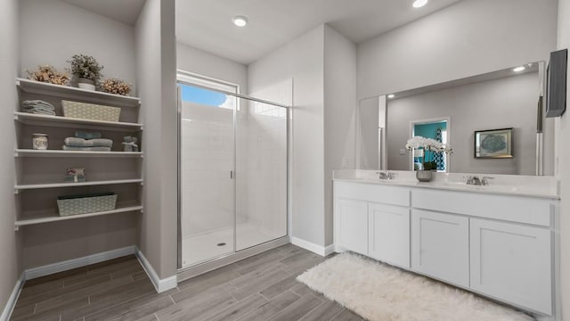 bathroom with a shower with door, vanity, and hardwood / wood-style flooring