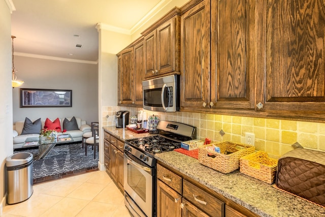 kitchen featuring tasteful backsplash, light stone counters, crown molding, light tile patterned floors, and appliances with stainless steel finishes