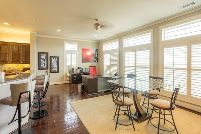 dining room with ceiling fan, ornamental molding, and dark wood-type flooring