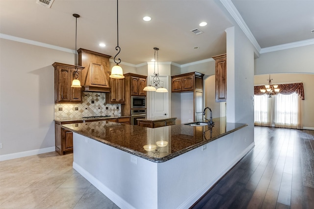 kitchen featuring appliances with stainless steel finishes, light wood-type flooring, sink, decorative light fixtures, and an inviting chandelier