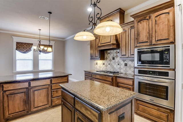 kitchen with a center island, dark stone countertops, light tile patterned floors, stainless steel appliances, and a chandelier