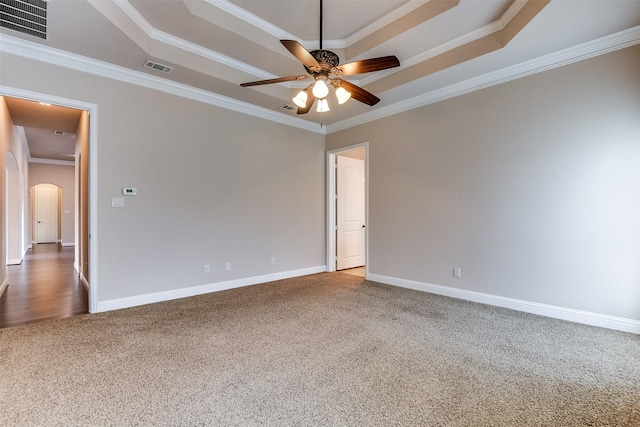 carpeted empty room with ceiling fan, ornamental molding, and a tray ceiling