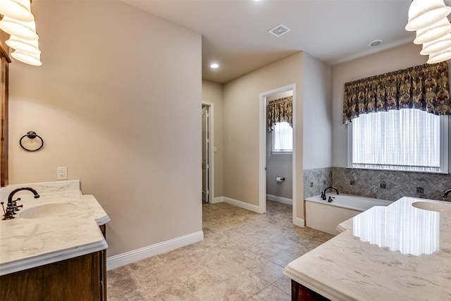 bathroom with a tub and vanity