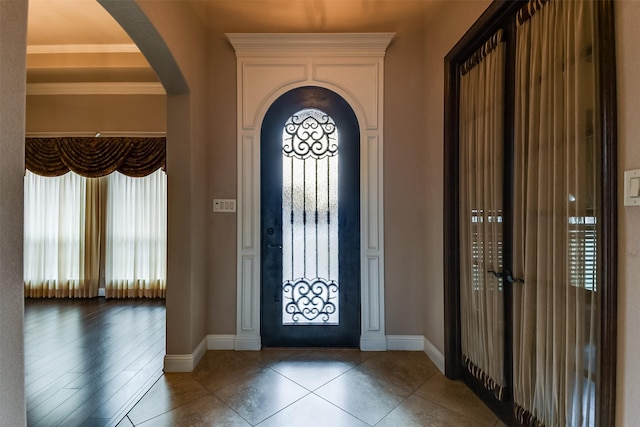 entryway featuring plenty of natural light, wood-type flooring, and crown molding