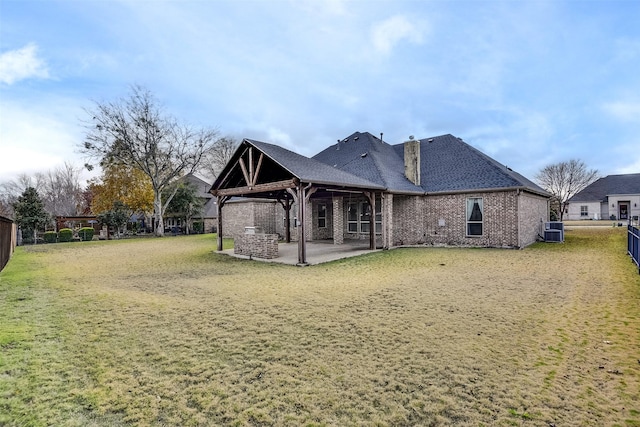 rear view of property with a lawn, a patio, and central AC