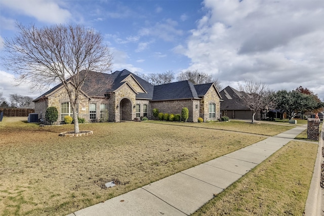 french country style house with a front yard and central air condition unit