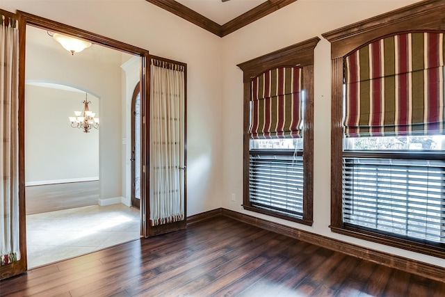 foyer entrance featuring crown molding, hardwood / wood-style floors, and an inviting chandelier