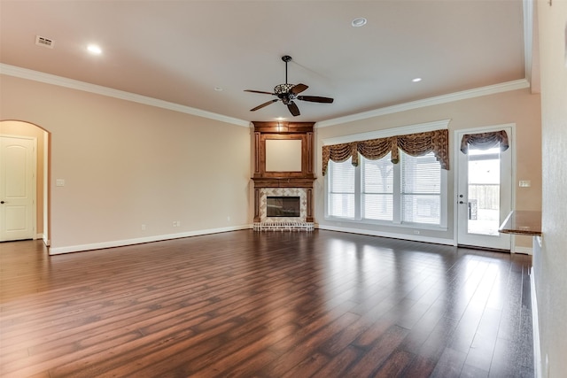 unfurnished living room featuring a high end fireplace, crown molding, dark hardwood / wood-style flooring, and ceiling fan